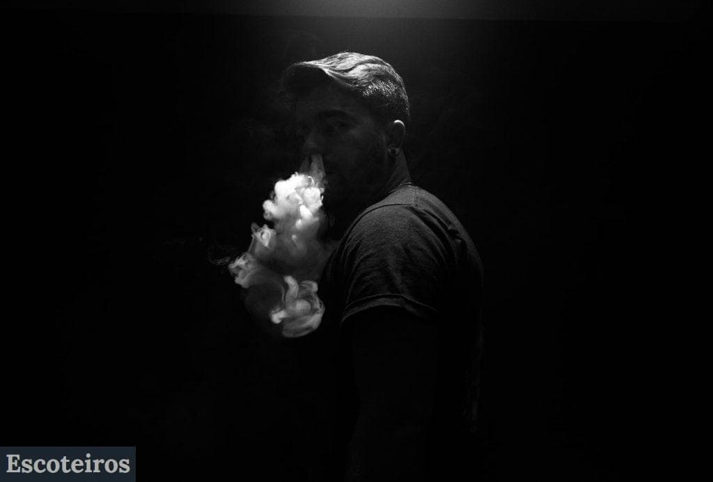 grayscale photo of man exhaling smoke
