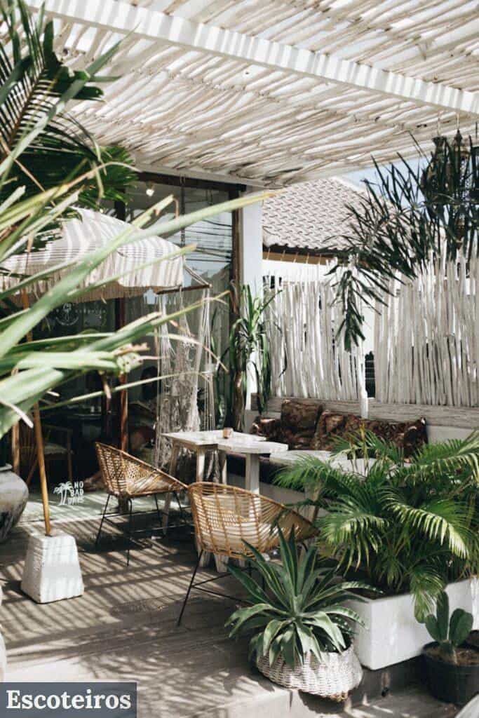 white table with brown wicker chair beside plants