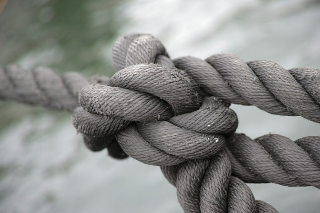 Nudo apretado en una cuerda gruesa de fibra gris